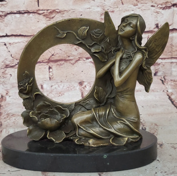 Fairy bronze sculpture with circular frame and floral design on marble base