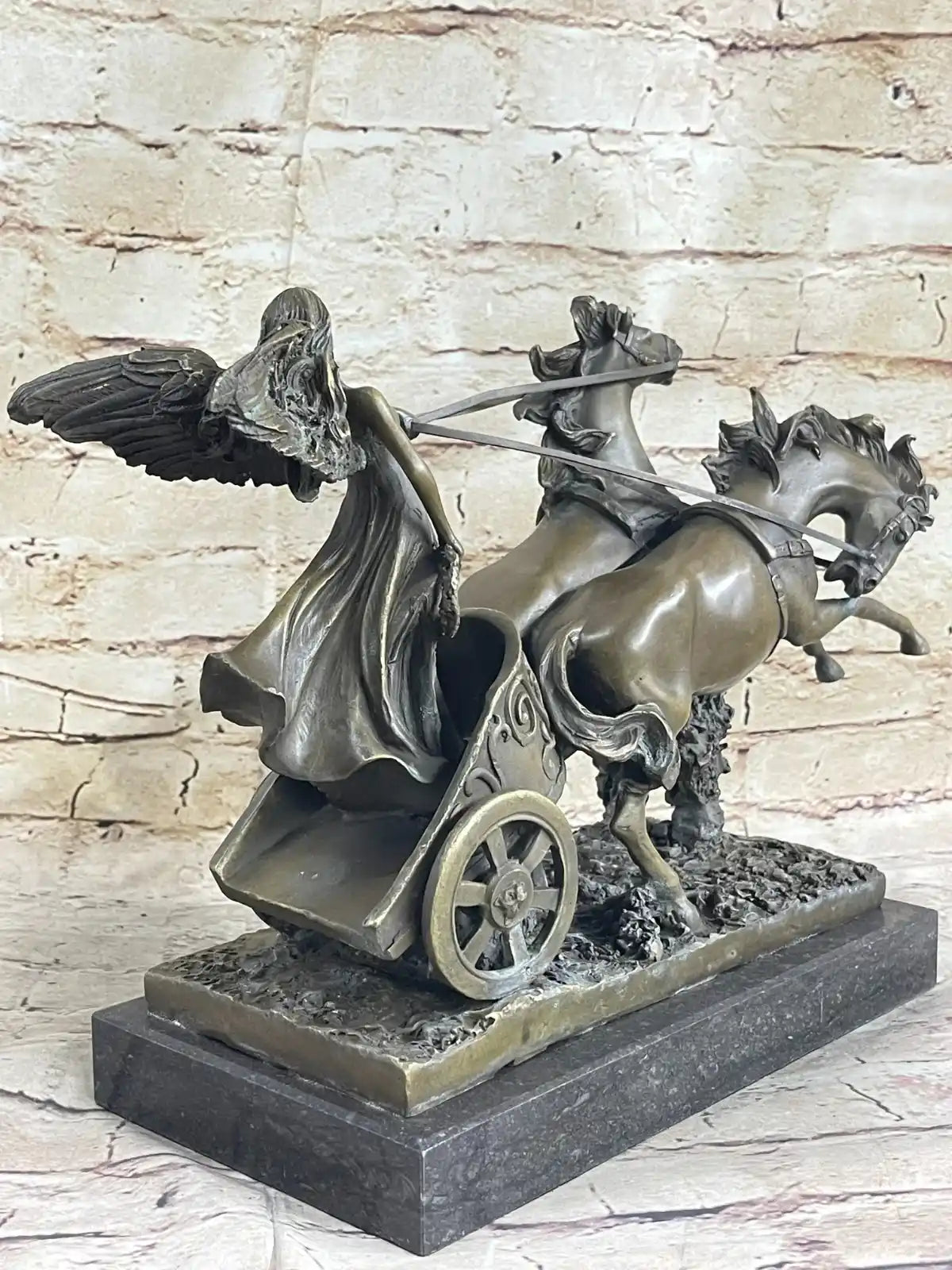 Detailed bronze sculpture of a winged angel driving a horse-drawn chariot on a marble base