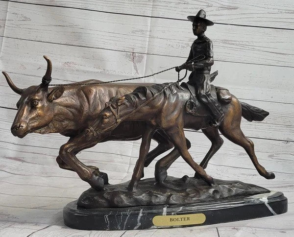 Bronze sculpture of a cowboy leading cattle with a dark marble base
