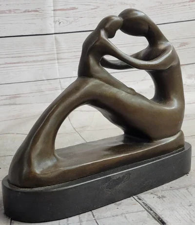 Abstract bronze sculpture of a romantic couple embracing on a marble base
