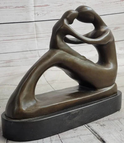 Abstract bronze sculpture of a romantic couple embracing on a marble base