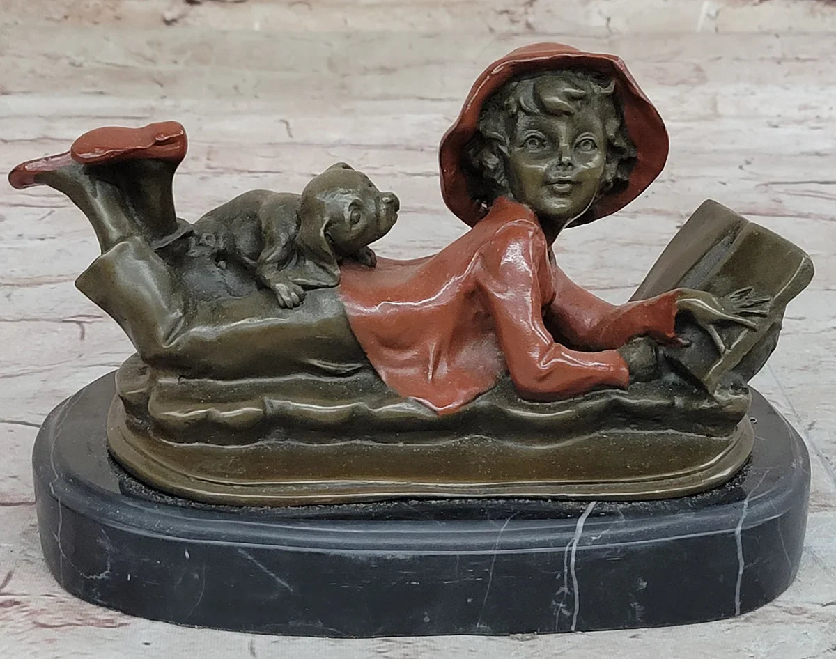Bronze sculpture of a smiling child and a puppy reading a book, capturing innocence in the artwork.