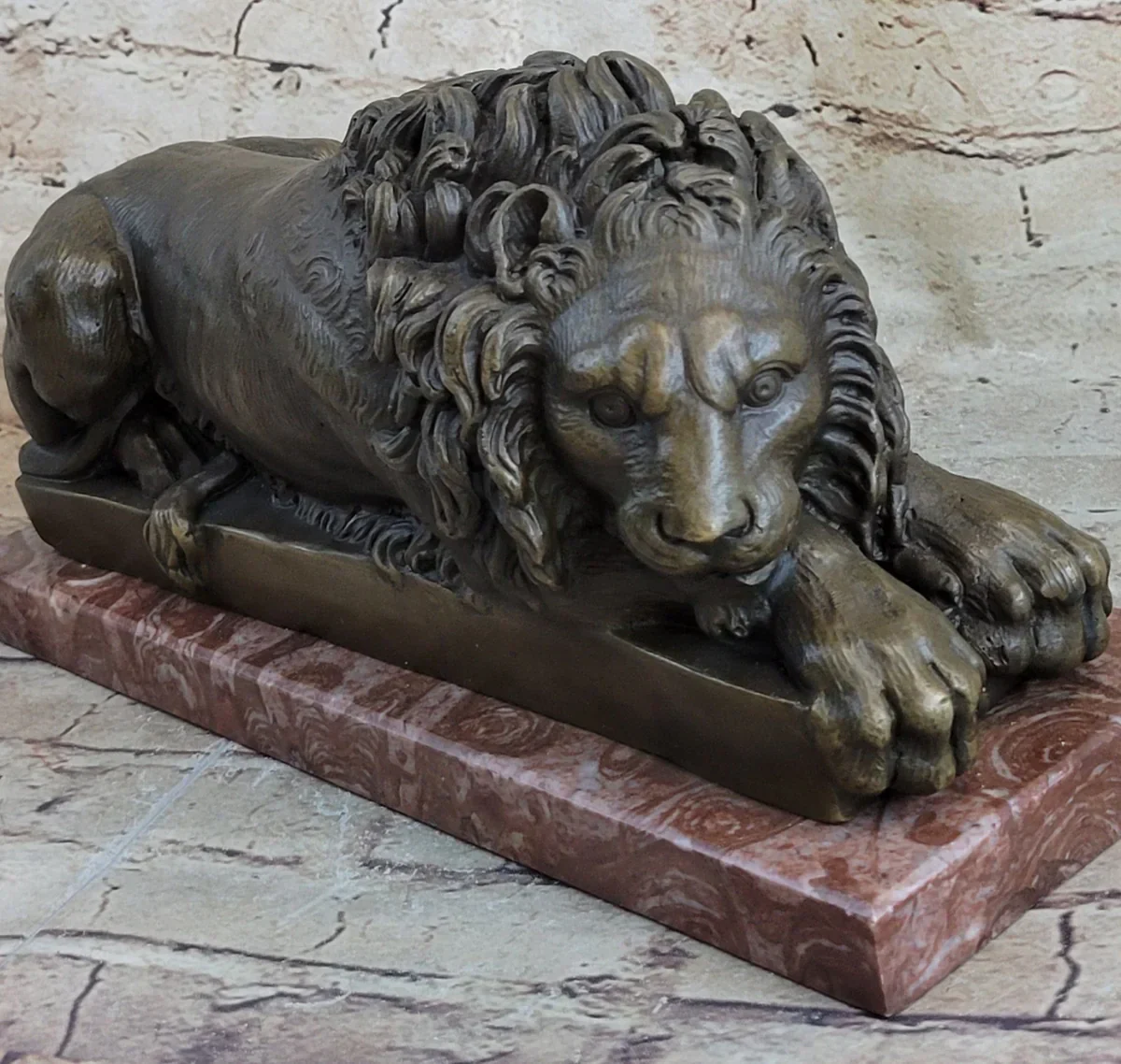  Bronze sculpture of a reclining lion with a detailed mane on a polished base